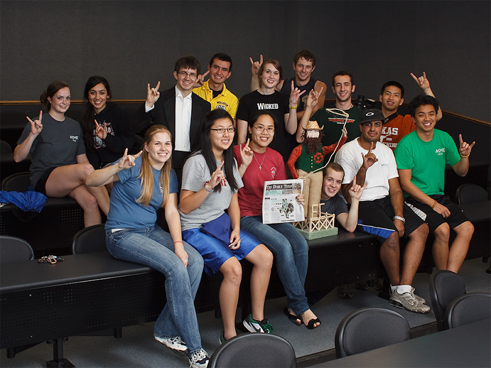 group of students doing hook 'em horns hands