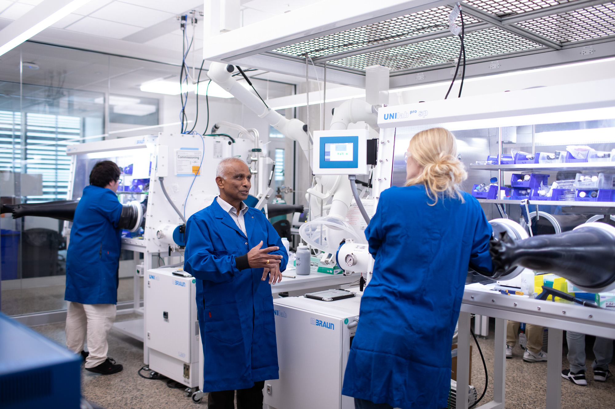 Mechanical engineering professor Arumugam Manthiram talks to students at his battery lab in the Gary L. Thomas building at The University of Texas at Austin.