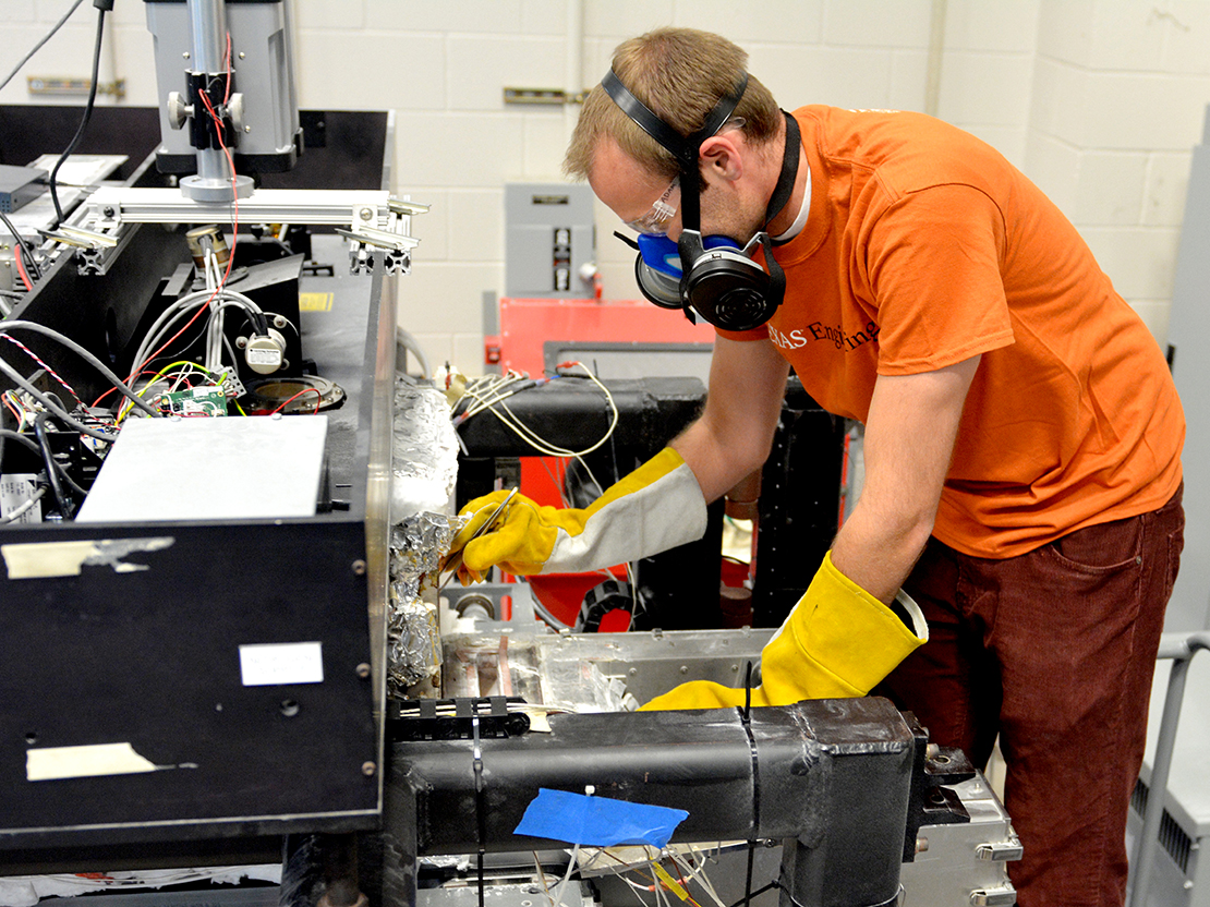 person at machine wearing gloves and face mask