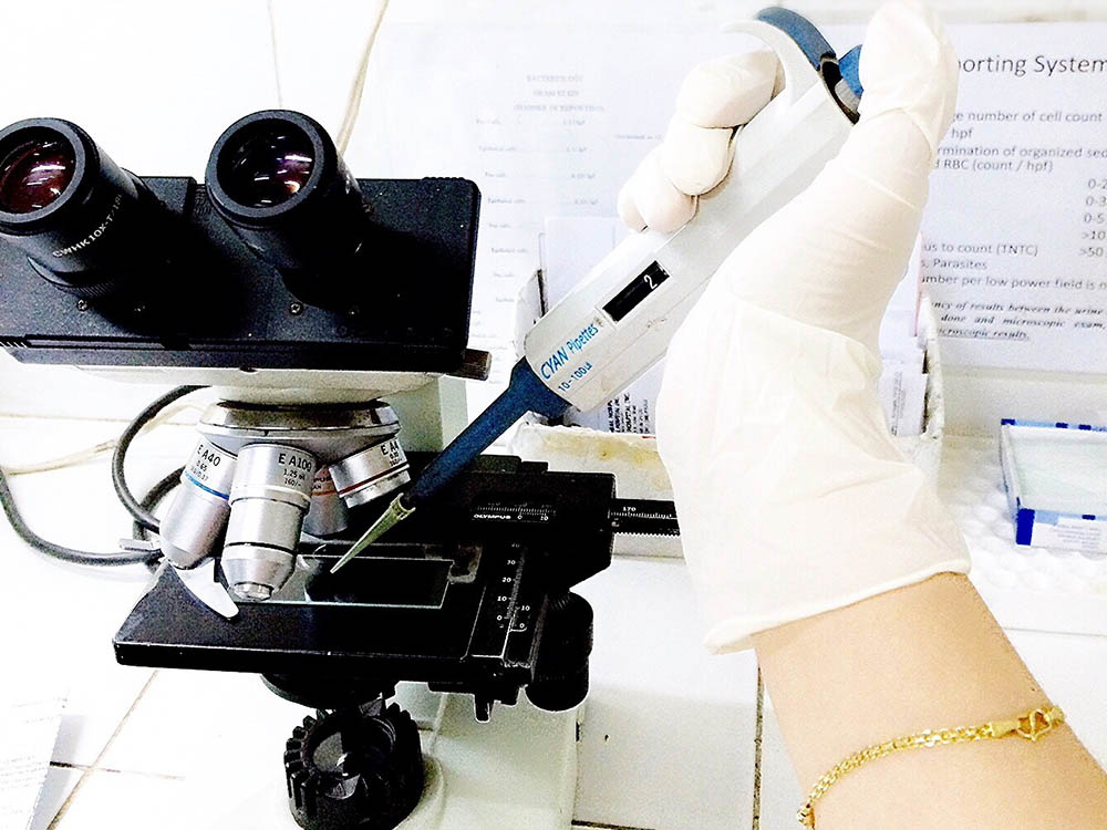 gloved hand with microscope