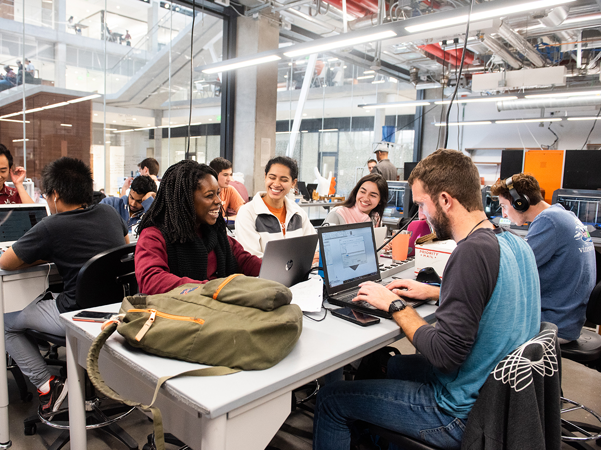 students work together around a table in Texas Inventionworks maker space